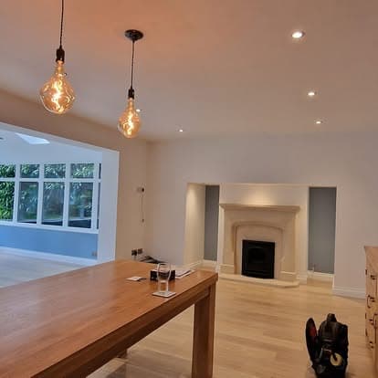 Open-plan dining room with feature pendant bulbs and recessed spotlights
